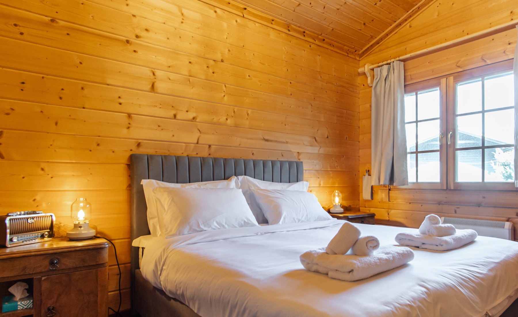 Pine-panelled bedroom with crisp white linens