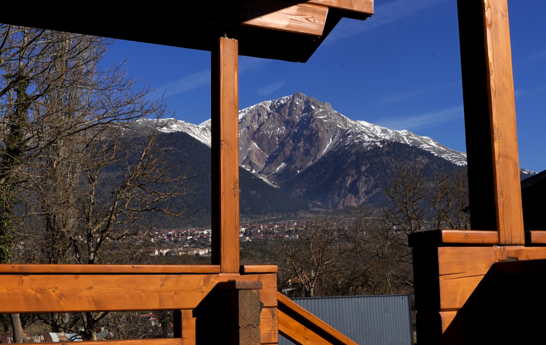 Mountain view over Karpenisi framed by the chalet balcony